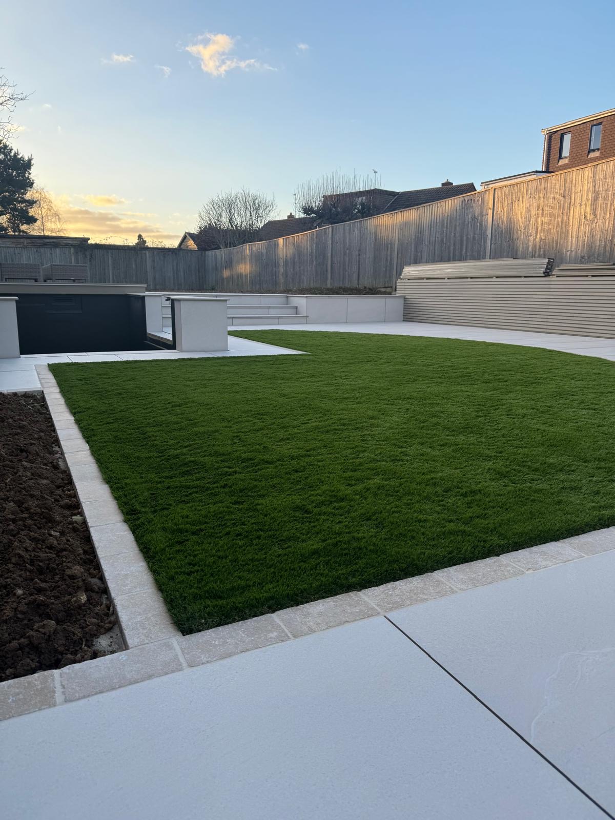 Daylight view showing the garden, koi pond, steps and landscaped context of the Smart Pond project