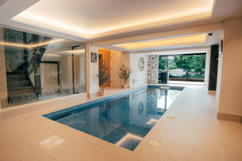 Indoor pool area with illuminated ceiling details and river views