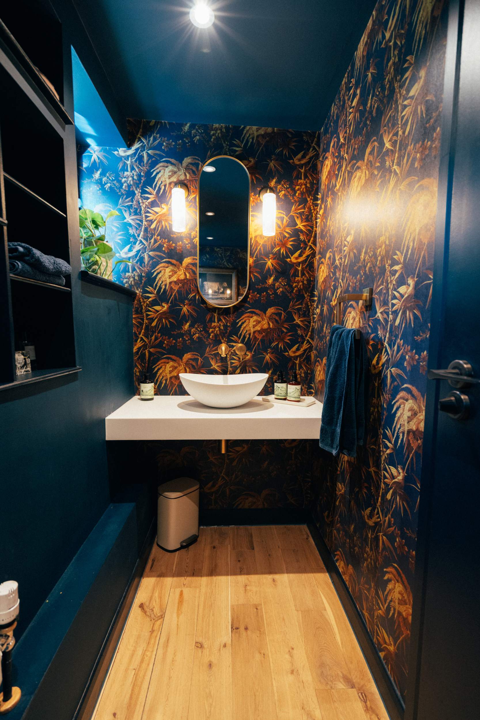 Bathroom lighting with wall-mounted fittings beside an arched mirror